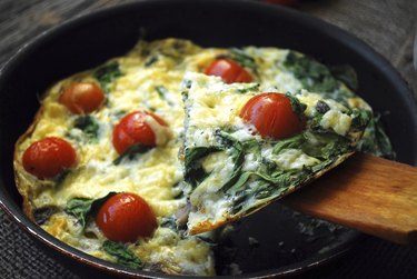 Frittata with cherry tomatoes, cheese and spinach. Close up