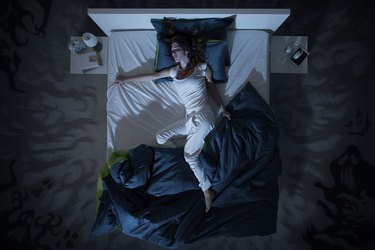 Top view of a woman in bed sweating in her sleep