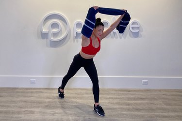 Woman doing a towel workout for back in a fitness studio