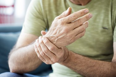Older adult holding their wrist after waking up with numb hands