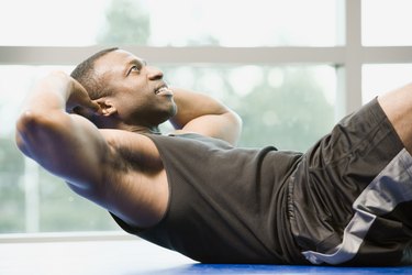 Person in workout clothes doing sit-ups at the gym to demonstrate how to exercise after inguinal hernia surgery/