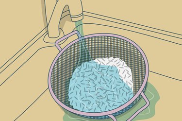 illustration of a colander of rice being rinsed in the sink under a running faucet.