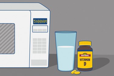 an illustration of a bottle of vitamin D supplements next to a glass of water and a white microwave showing 5 am on the clock, signifying taking vitamins on an empty stomach